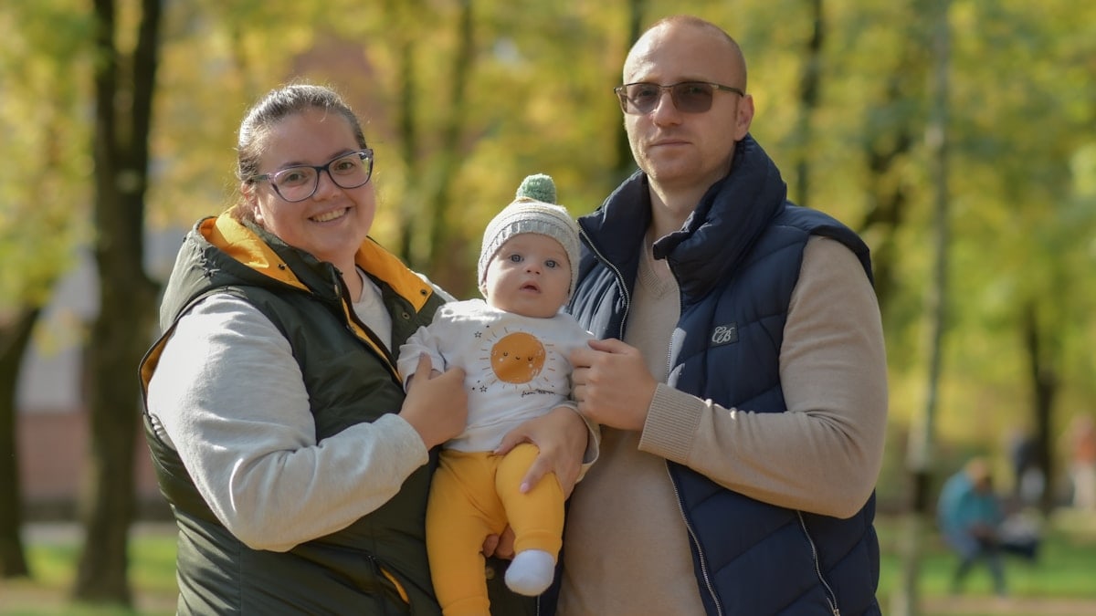 a man and woman holding a baby